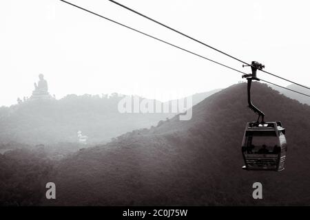 Téléphérique à Ngong Ping à Hong Kong avec le Bouddha Tian Tan en arrière-plan sur l'île de Lantau Banque D'Images