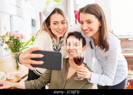 Jeunes femmes sur le smartphone de la fête de poule avec la mariée avant le mariage Banque D'Images