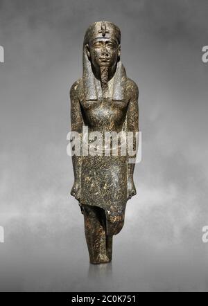 Ancienne statue égyptienne d'un roi ptoléméen dans la régalia pharaonique, granodiorire, période ptoléméenne (332-30BC). Musée égyptien, Turin. Fond gris Banque D'Images