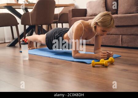 FIT jeune femme faisant un exercice de planche d'avant-bras pendant son  entraînement de fitness à la maison Photo Stock - Alamy