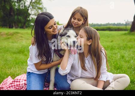 Deux belles sœurs avec leur mère et leur chien Husky au parc. Famille heureuse avec leur animal de compagnie dans la campagne Banque D'Images