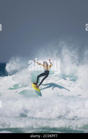 Une action spectaculaire en tant que jeune surfeur fait une vague à Fistral à Newquay, en Cornouailles. Banque D'Images