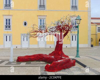 Arbre rouge, Cascais, Portugal. Magnifique édifice jaune en arrière-plan, le Pousada historique Pestana Cidadela hôtel de luxe et art Banque D'Images