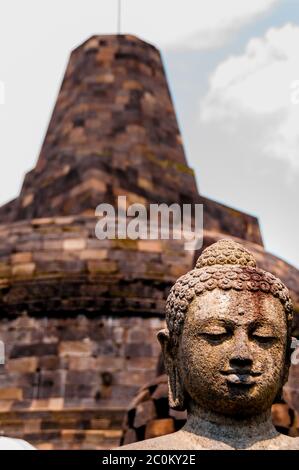 Pierre sculpure Bouddha assis en face de stupa Banque D'Images