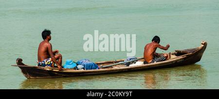 Deux hommes asiatiques l'aviron bateau en bois sur une rivière Banque D'Images