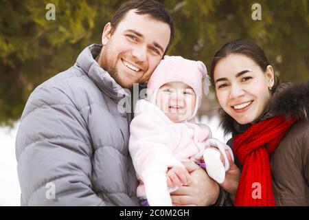 Une famille heureuse portant des vêtements chauds dans le parc d'hiver Banque D'Images