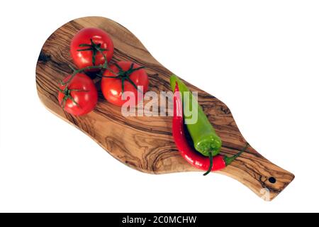 Trois tomates rouges fraîches et piment sur la planche à pain Banque D'Images