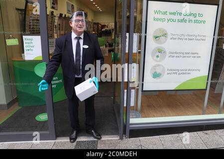 David Maguire, directeur de Specsavers à Belfast, reçoit un forfait, après que tous les centres commerciaux et les détaillants ont reçu le feu vert pour rouvrir dans un assouplissement significatif des restrictions de verrouillage du coronavirus en Irlande du Nord. Banque D'Images