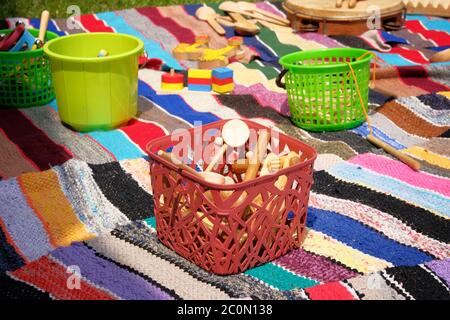 Jouets rétro en bois dans un panier sur un tapis de couleur. Jouets anciens, style de couleur vintage. Banque D'Images