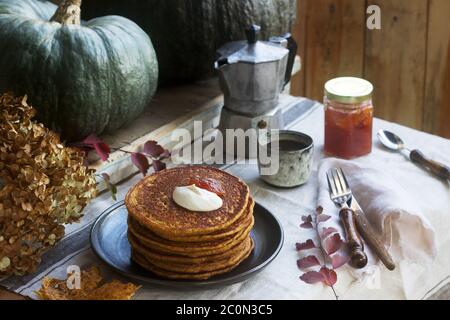 Crêpes à la citrouille avec crème et de la confiture sur un fond d'automne de la vie encore. Banque D'Images