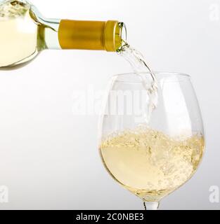 Vin blanc versé dans le verre d'une bouteille Banque D'Images