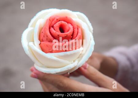 Des mains de femmes portant une jolie crème glacée rose et blanche en forme de rose à Séoul en Corée du Sud Banque D'Images