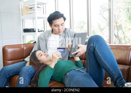 Un couple holding credit card on digital tablet, relation, la technologie moderne, les achats en ligne concept. Banque D'Images