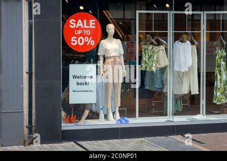 Worthing, Royaume-Uni, 12 juin 2020. Alors que les magasins se préparent à rouvrir pendant la crise pandémique du coronavirus COVID-19, un ouvrier d'atelier met un panneau Welcome Back dans la fenêtre d'une boutique de vêtements. Crédit : Scott Ramsey/Alay Live News. Banque D'Images