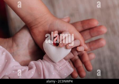 Mains des femmes tenant la main de l'enfant avec un cœur. Le concept de la maternité, de la compassion, de la famille, de la protection, de l'amour. Placer pour le texte. Humanitaire mondiale d Banque D'Images