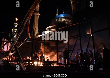 Beyrouth, Liban, 11 juin 2020. Les gens regardent comme un incendie brûle devant la Grande Mosquée lors des émeutes à Beyrouth et à travers le Liban, après une dépréciation de 25% de la livre libanaise en 48 heures. Banque D'Images