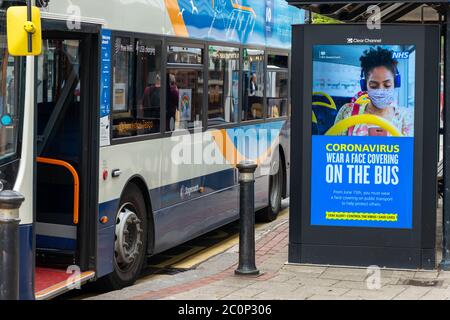 Worthing, Royaume-Uni, 12 juin 2020. Sur un arrêt de bus, un panneau d'affichage numérique affiche un message du coronavirus du gouvernement HM et du NHS informant les gens qu'ils doivent porter un masque de protection lorsqu'ils voyagent en transports publics à partir du 15 juin. Crédit : Scott Ramsey/Alay Live News. Banque D'Images