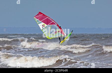 Portobello, Édimbourg, Écosse, Royaume-Uni. 12 juin 2020. Vent exceptionnellement bon dans la bonne direction pour deux surfeurs juste au large de Portobello sur le Firth of Forth, vent de l'est 25km/h avec des rafales potentielles de 47 km/h à intervalles lumineux. Les deux gars Jake et Tom étaient sur la côte est depuis 5am à la recherche des conditions, c'était la dernière demi-heure avant de rentrer à la maison. Banque D'Images