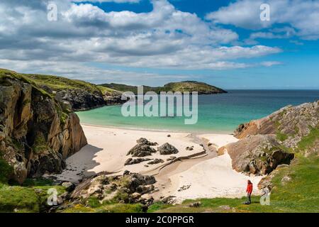 ACHMELVICH BAY AND BEACH SUTHERLAND HIGHLANDS SCOTLAND BLEU CIEL AVEC DES NUAGES LES NOMBREUSES COULEURS DE LA MER ET UN RANDONNEUR SOLITAIRE Banque D'Images