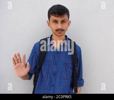 Photo de l'élève de l'adolescence montre stop geste, isolé sur fond blanc. Banque D'Images