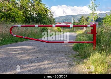 La route est fermée par une barrière. Rambarde blanche et rouge. Construction métallique. Aucune entrée. Banque D'Images