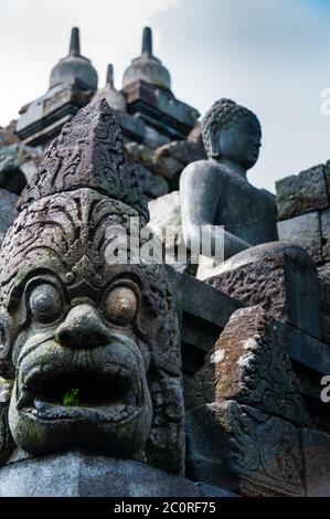 Trop assis et Sculpture Bouddha en pierre au temple de Borobudur Banque D'Images