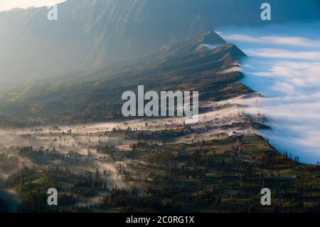 Couche de brume sur les montagnes et dans un village Banque D'Images