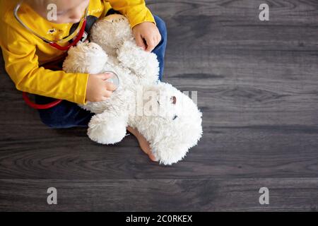 Enfant doux, médecin, jouet ours en peluche à la maison, arrière-plan isolé Banque D'Images