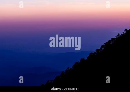 Silhouette de versant de montagne Tajumulco avec arbres devant rose violet bleu coucher soleil Banque D'Images