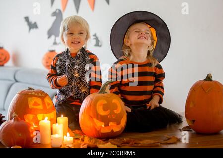 Adorables enfants, tout-petits et filles, jouant avec la citrouille sculptée d'Halloween et la décoration à la maison Banque D'Images