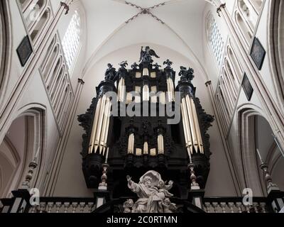 Tuyaux d'orgue noirs dans l'ancienne église catholique blanche Banque D'Images