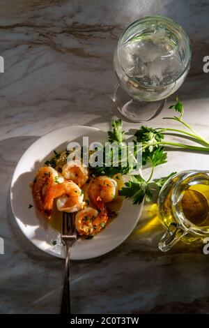 Dîner portugais camarao ao alho e oleo crevettes à l'ail aux rayons du soleil spectaculaires Banque D'Images