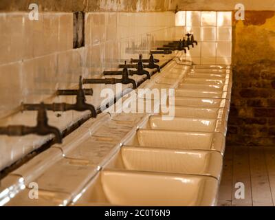 Rangée de lavabos dans la salle de bains de l'ancienne prison, image sépia Banque D'Images