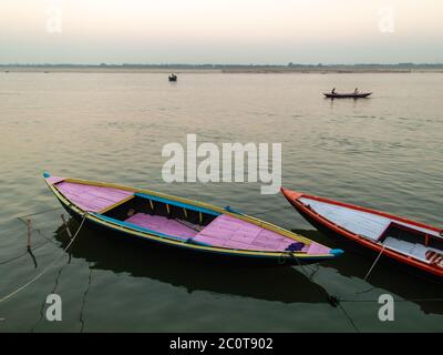 Varanasi, Uttar Pradesh, Inde - février 2015 : bateaux colorés tournant sur les rives du Ganga par les vieux ghats de la ville antique. Banque D'Images