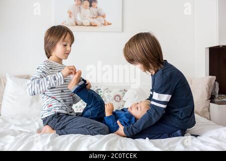 Enfants, frères, jouer à la maison, chatouiller les pieds rire et sourire Banque D'Images
