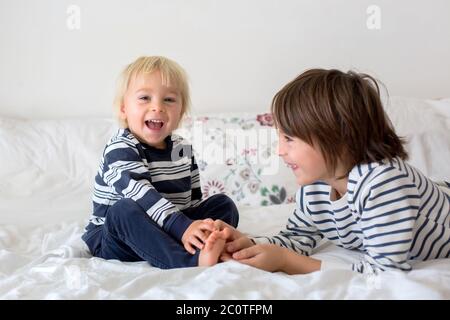 Enfants, frères, jouer à la maison, chatouiller les pieds rire et sourire Banque D'Images