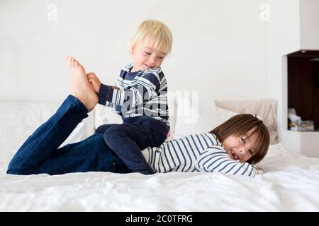 Enfants, frères, jouer à la maison, chatouiller les pieds rire et sourire Banque D'Images