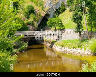 Trou d'hirondelle de la rivière PIVKA avec pont pour piétons. Lieu où la rivière Pivka entre dans la grotte de Postojna, Slovénie. Banque D'Images