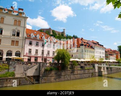 Bâtiments sur la rive du centre-ville de Ljubljana et château de Ljubljana sur la colline, Slovénie Banque D'Images