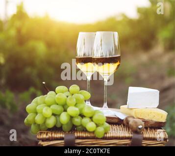 Diverses sortes de fromage, de raisins et deux verres de vin blanc Banque D'Images