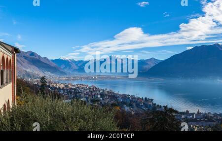 Vue panoramique aérienne imprenable sur Locarno et le lac majeur depuis l'église Madonna del Sasso, la montagne enneigée des Alpes suisses et le ciel bleu du Clo Banque D'Images