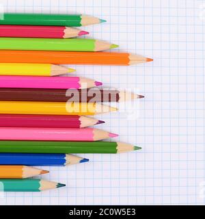 Colorer les crayons contre une feuille en cage Banque D'Images