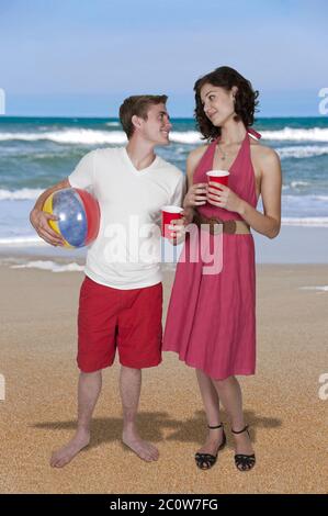 Couple qui boit à la plage Banque D'Images