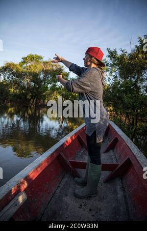 femme blonde pêchant sur un canoë dans la rivière Banque D'Images