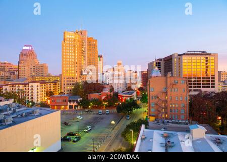 Bâtiment historique sur E Commerce St avec Weston Center et Nix Professional Building à l'arrière-plan au lever du soleil dans le centre-ville de San Antonio, Texas, États-Unis. Banque D'Images