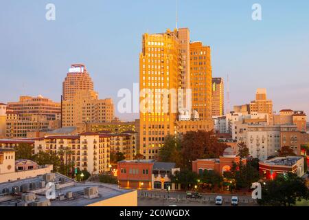 Bâtiment historique sur E Commerce St avec Weston Center et Nix Professional Building à l'arrière-plan au lever du soleil dans le centre-ville de San Antonio, Texas, États-Unis. Banque D'Images