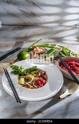 Soupe vietnamienne traditionnelle de nouilles de bœuf au pho bo servie avec des nouilles, des champignons de coriandre au basilic et des pousses de haricots Banque D'Images