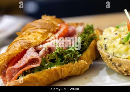 Croassant et casière avec jambon et œufs. Banque D'Images