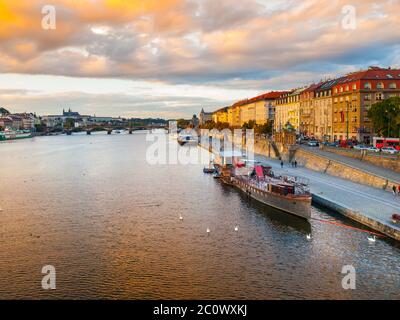 Vue en soirée sur le quai Rasin avec des bateaux sur la Vltava à Prague, République tchèque Banque D'Images