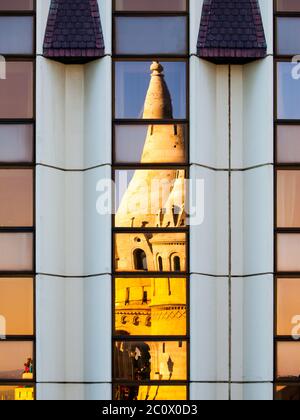 Vue détaillée du reflet voilé du Bastion des pêcheurs, alias Halaszbatya, tours de conte de fées dans les fenêtres de l'hôtel moderne. Interprétation architecturale de l'historique et architecture moderne détestée de la Hongrie communiste. Budapest, capitale de la Hongrie, Europe. Patrimoine mondial de l'UNESCO Banque D'Images